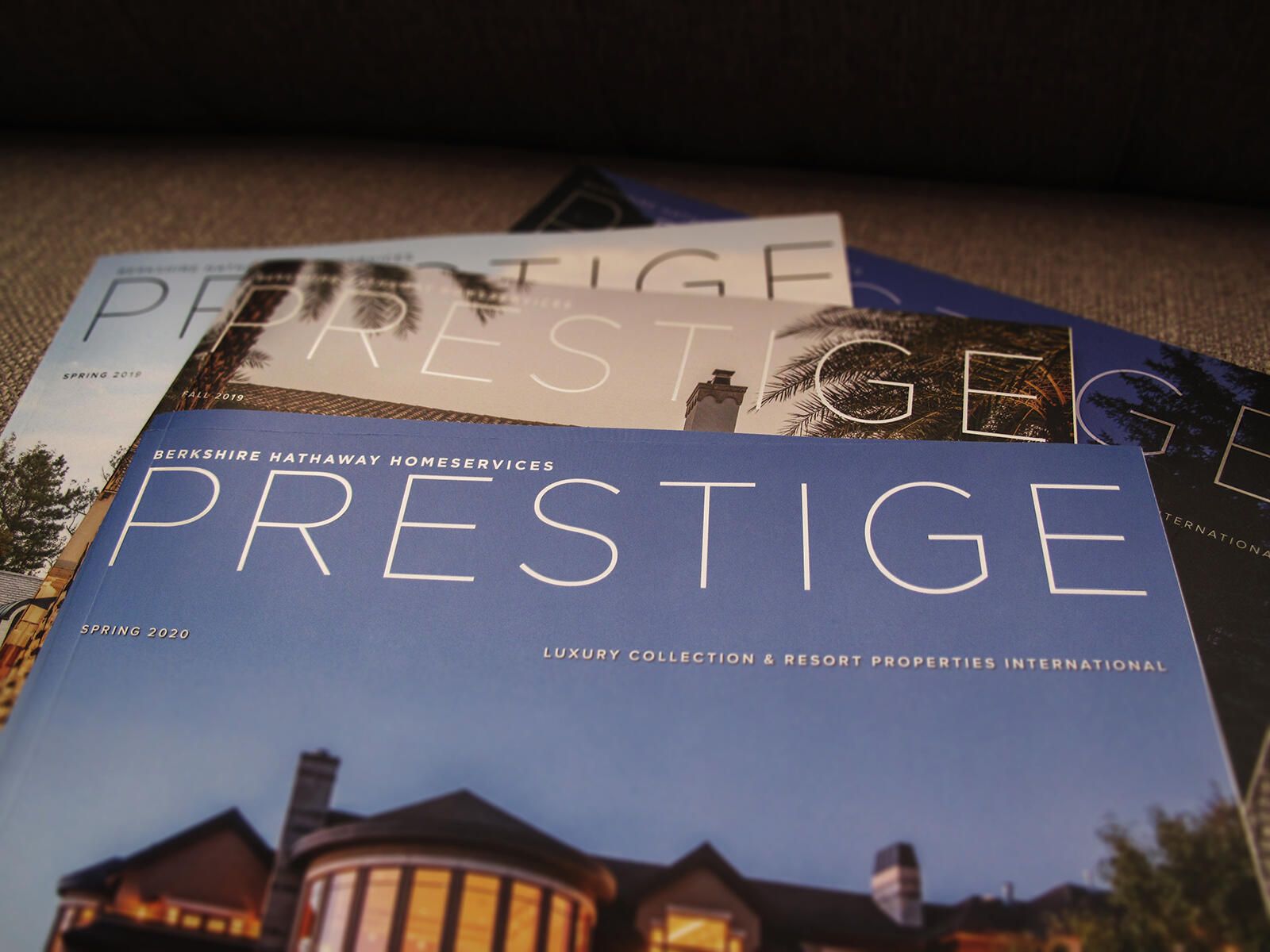 Four 'Prestige' magazines partially spread out on a table