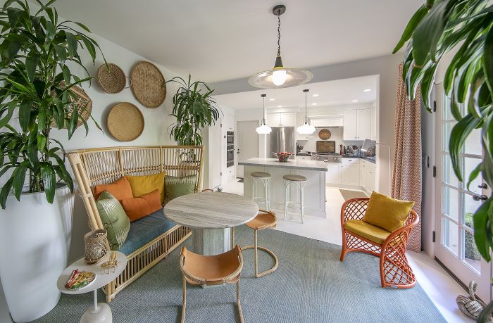 Sunny dining area of a Montecito townhouse, with the kitchen in the background and French doors.