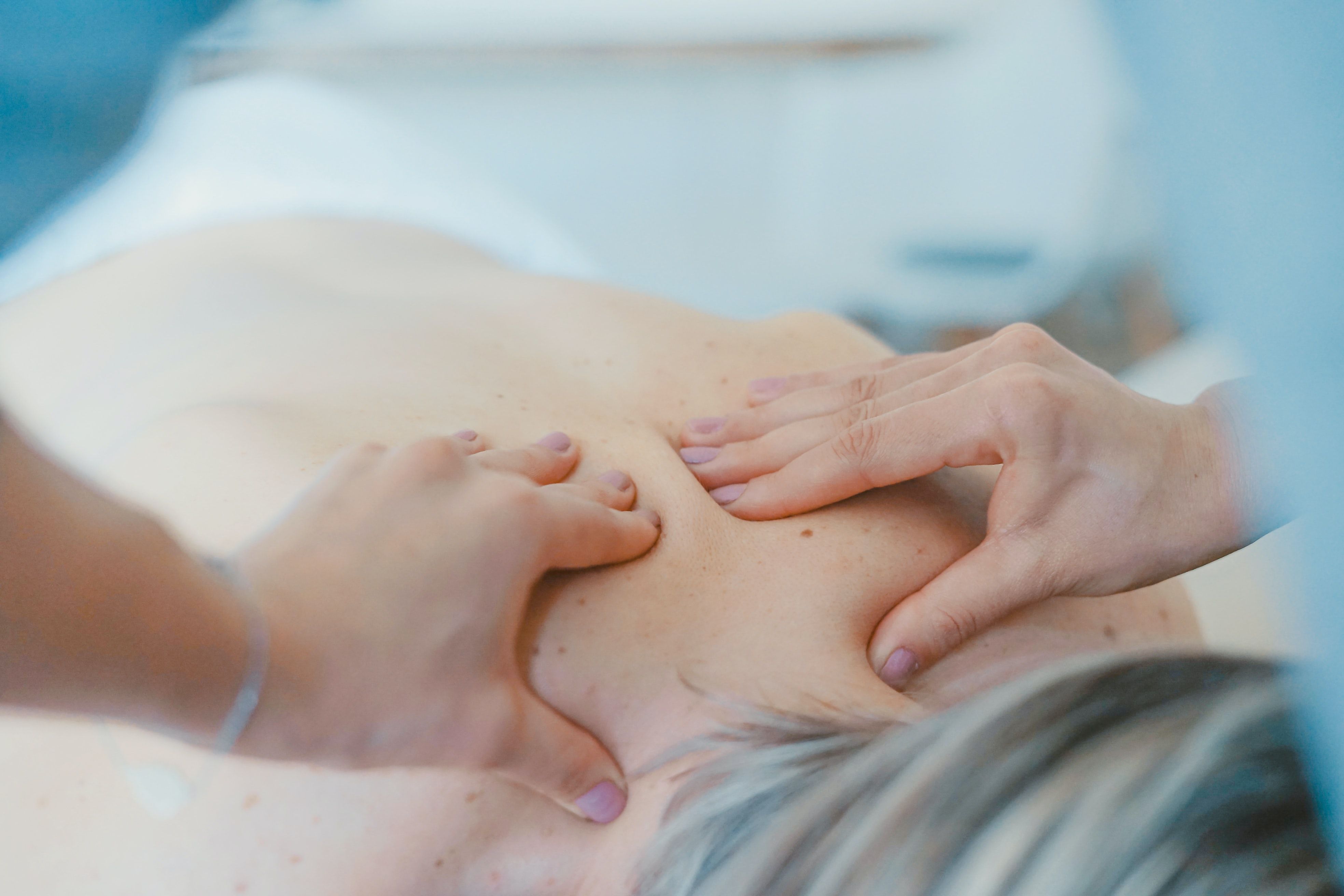 Hands of a massage therapist rubbing a woman's back