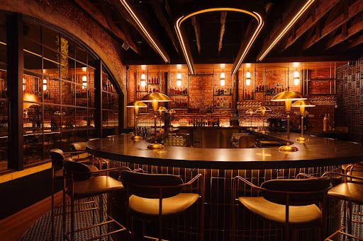 The inside bar at the retro swanky Santa Barbara restaurant Rare Society steakhouse. It's dark with mood lighting with a horseshoe bar