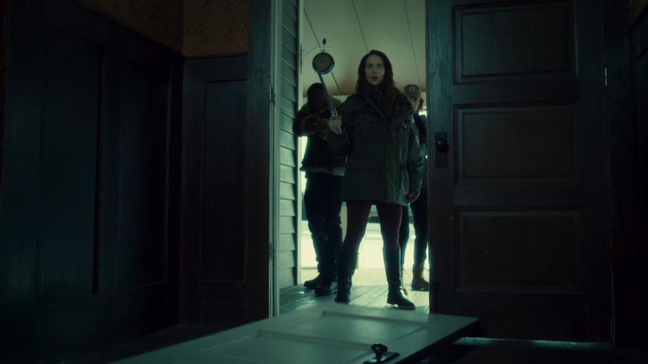 Dolls, Wynonna, and Nicole stand in the entrance of the mansion after Wynonna kicked down the door.