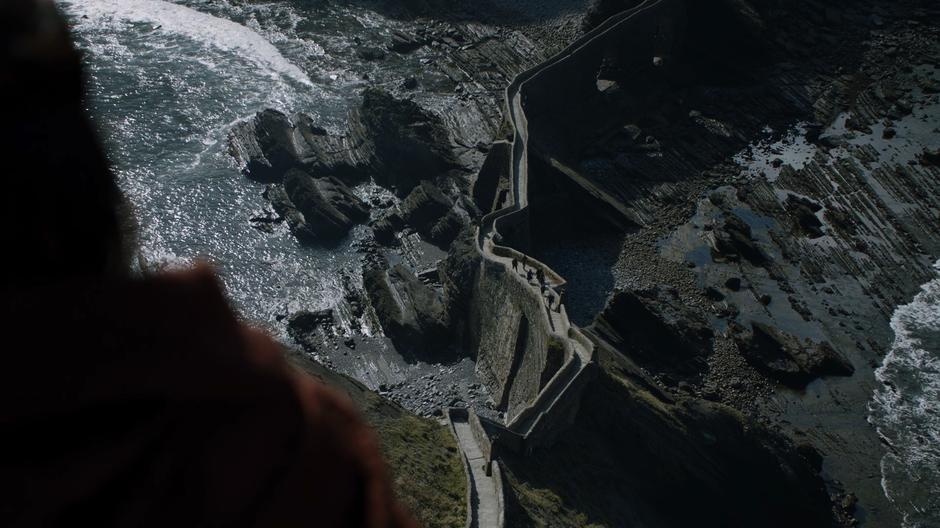 Melisandre looks down at the path that the newcomers are climbing.