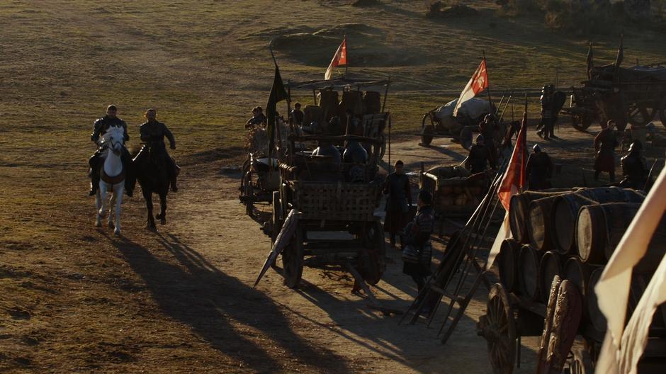Jaime and Bronn ride down the line to where a wagon is broken down.