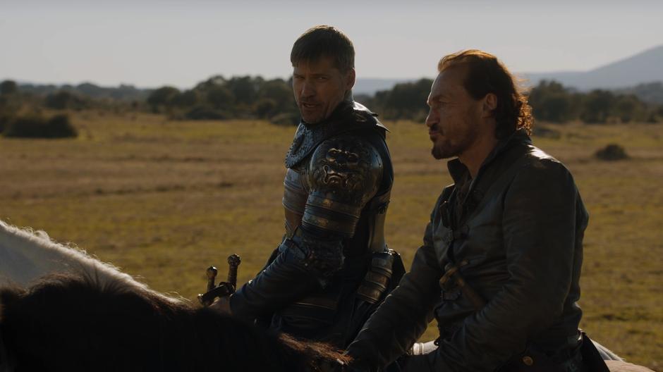 Jaime talks to Bronn while mounting his horse.