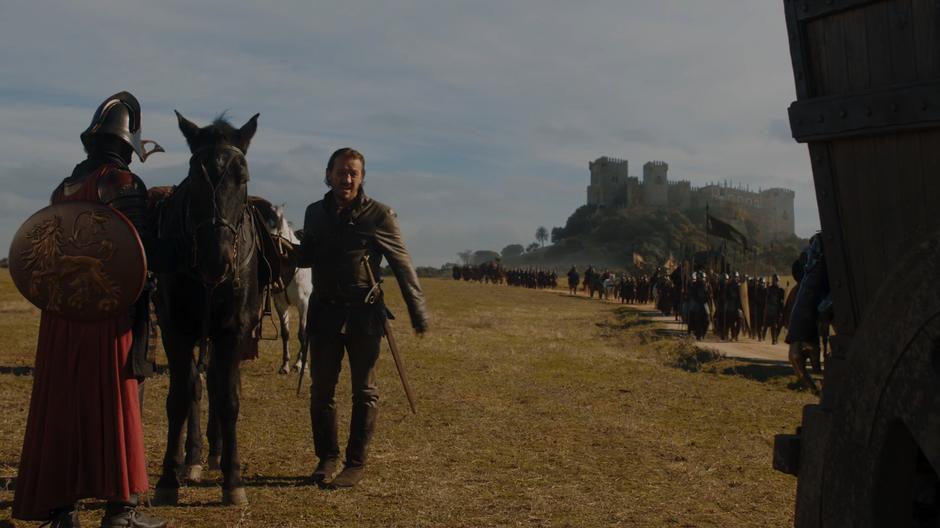Bronn talks to Jaime while attaching his new gold to his horse.