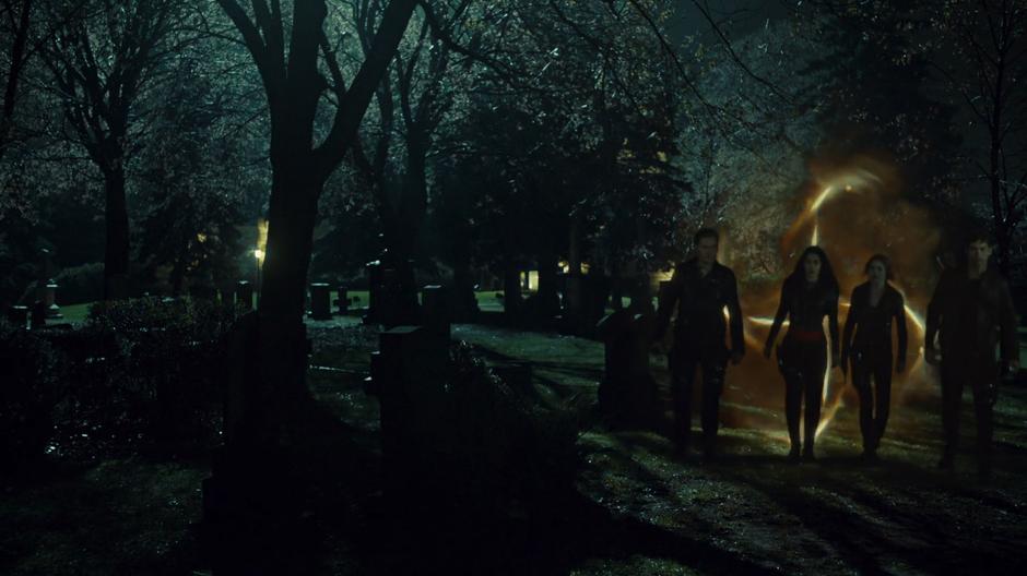 Jace, Izzy, Clary, and Alec enter the cemetery through a portal.