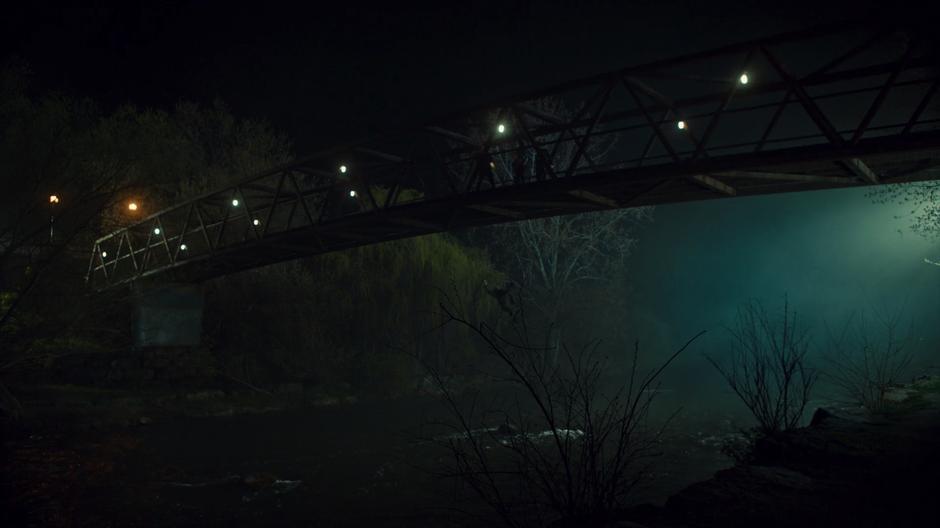 Jonathan plumets to the river below after loosing the fight while the others watch from the bridge.