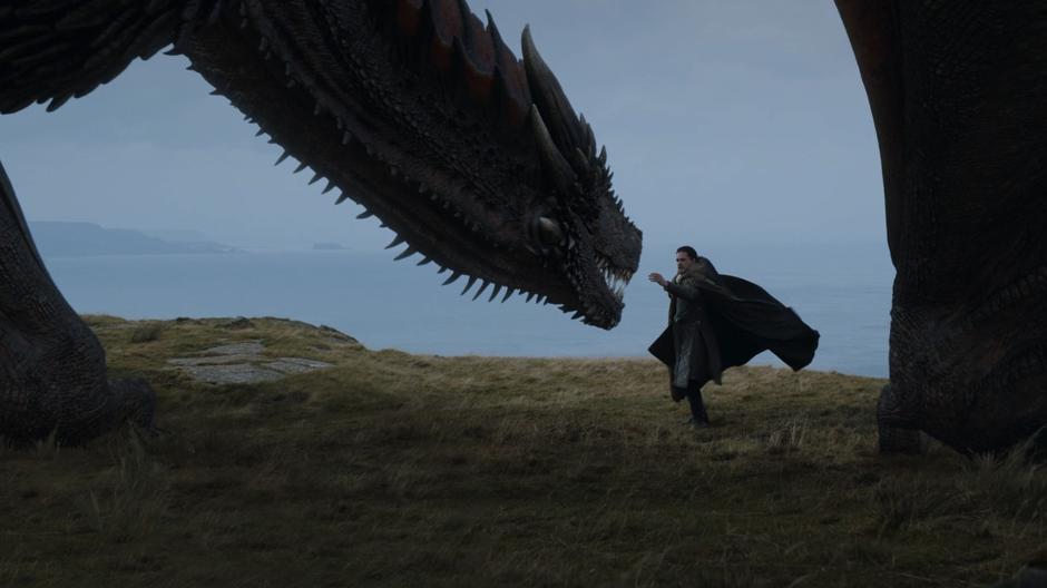 Jon reaches out to pat Drogon on the snoot.