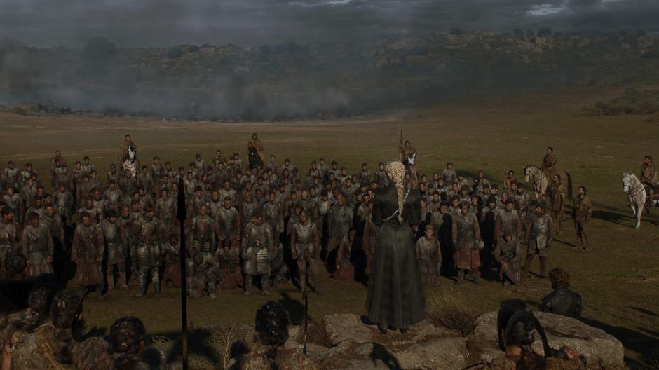 Daenerys addresses the captured Lannister soldiers while the battlefield continues to smolder in the background.