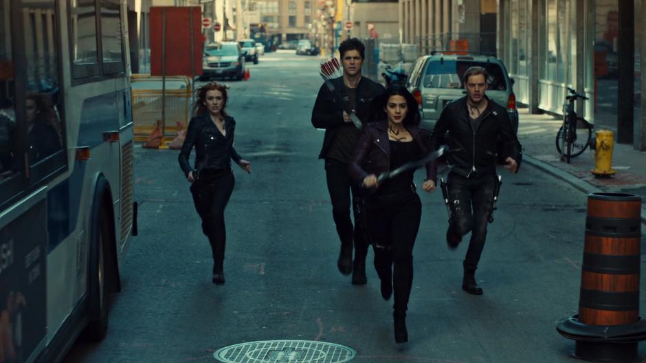 Clary, Alec, Izzy, and Jace run down the street towards where the demon is circling.