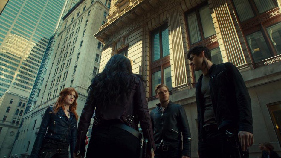 The gang discusses the worrisome news about the Seelie Queen while standing in an alley off the main road.