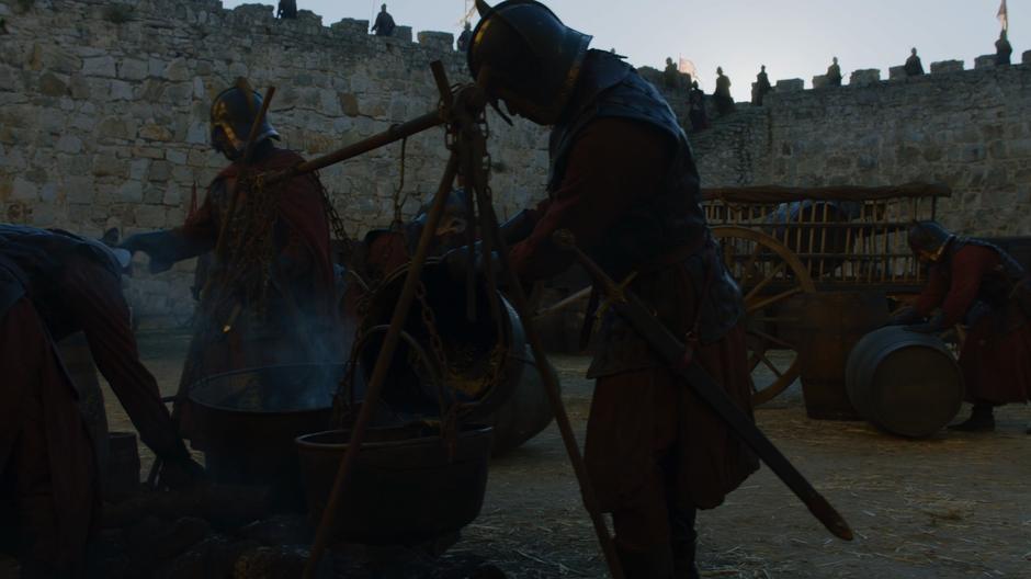 Lannister soldiers prepare barrels of pitch in case of attack.