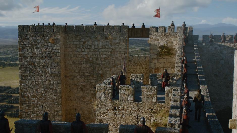 Bronn walks along the wall's battlements.