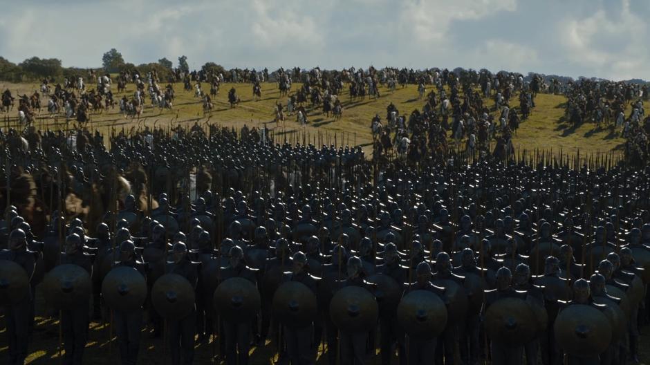 The Dothraki ride through the Unsullied who are standing in formation.