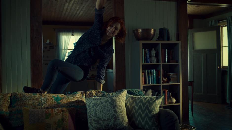 Nicole jumps over the couch to pull the Widow off of Waverly.