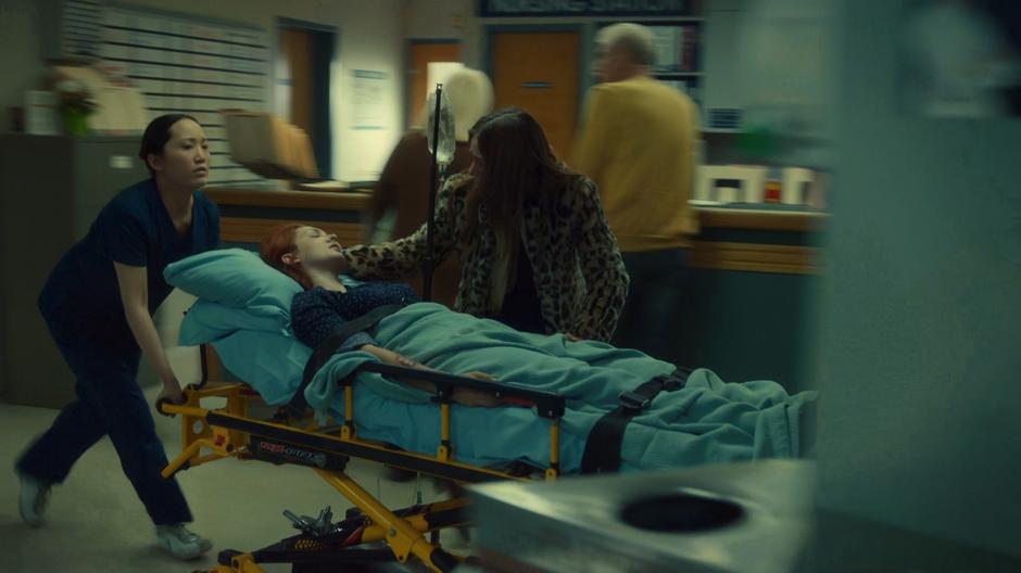 Waverly walks next to the gurney as Nicole is being wheeled through the hospital.