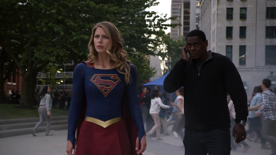 Kara and J'onn land on the plaza and search for clues about the explosion.