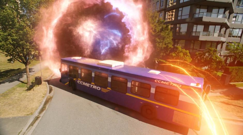 A bus stops in front of the open portal and Barry rushes over the top using his superspeed.