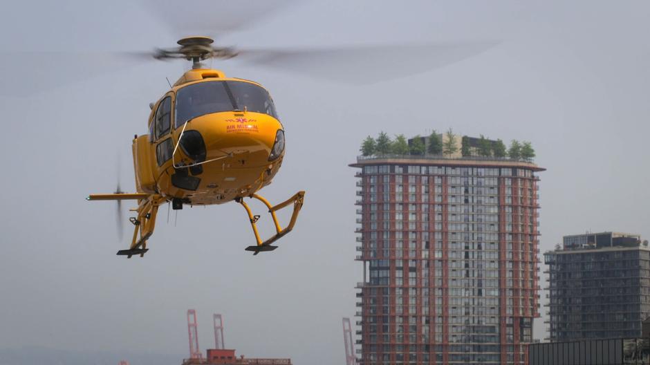 The helicopter lifts off from the top of the hospital.