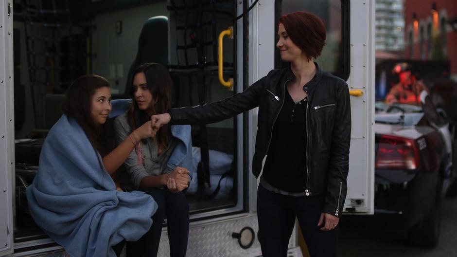 Alex fist bumps Ruby while Sam looks at her daughter with concern.
