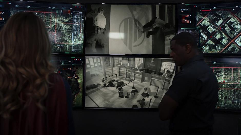 Kara and J'onn watch the footage of the bank robbery in progress.