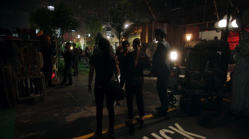 Ella, Chloe, and Lucifer get stopped by a PA at the door of the sound stage.