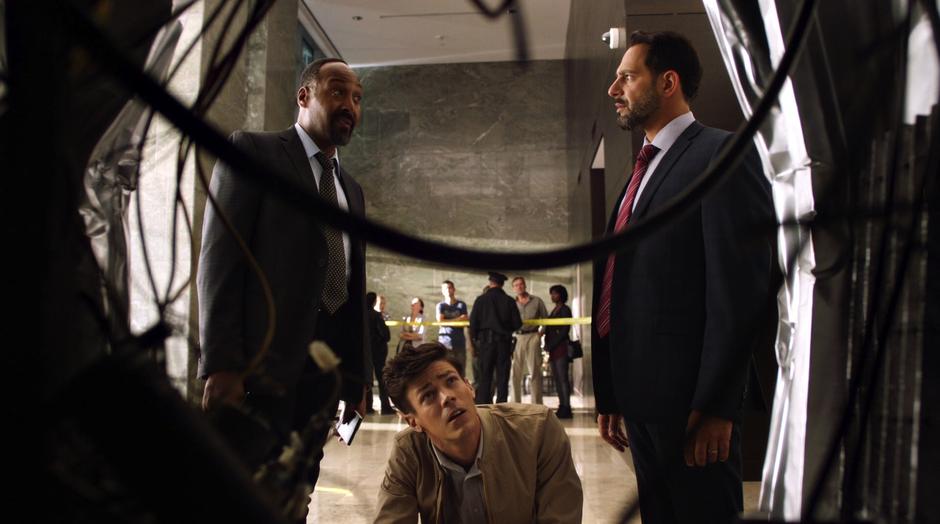 Barry examines the interior of the elevator while Joe talks with Captain Singh.