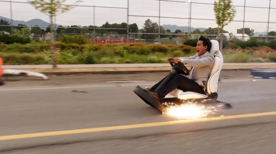 Tim Kwon screams as he slides down the road on just his car's seat.