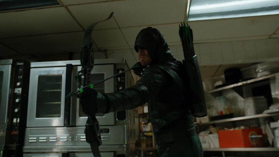 Oliver fires an explosive arrow at the door of the freezer where the executives are being held.