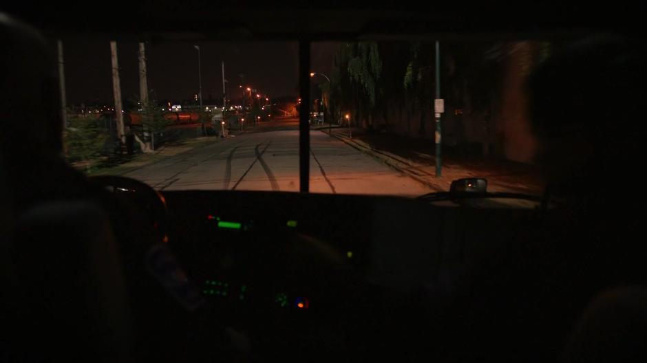 The two drivers look out the front of their cab at the empty street.