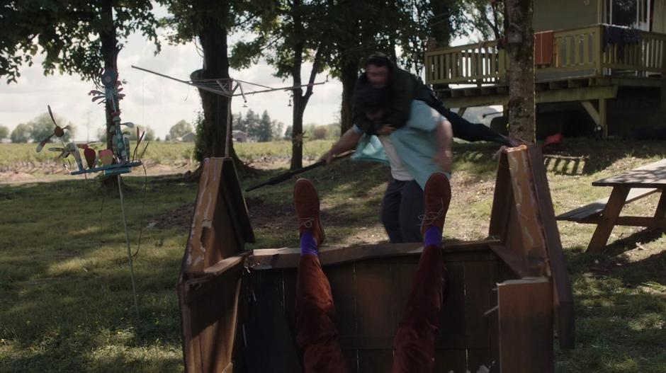 Todd hangs on Bob Boreton's back as Bob tries to shake him off and Dirk lies on the ground after being thrown onto the dog house.