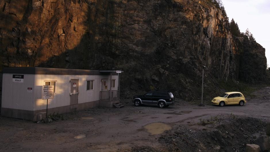 Establishing shot of the quarry office with Suzie's car parked out front.