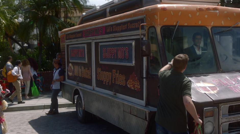 A random guy knocks on the window of the undercover food truck while Lucifer sits inside.