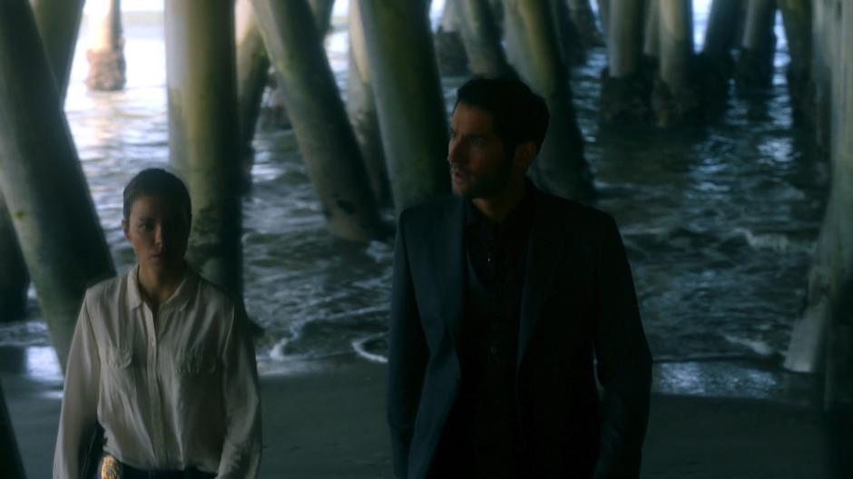Chloe and Lucifer walk under the pier to the crime scene.