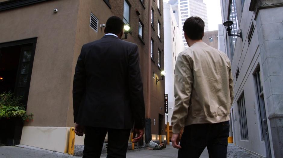 Joe and Barry watch as Ralph Dibny settings onto the ground after stretching from the roof.