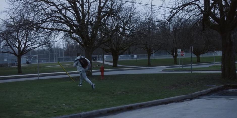 Trevor runs out of the lot and across the grass.