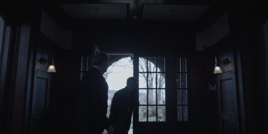 A guard holds the door open for Grant as he enter the mansion.