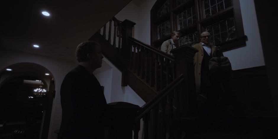Vincent comes down the stairs with his son and tells one of his guards that they are leaving for good.