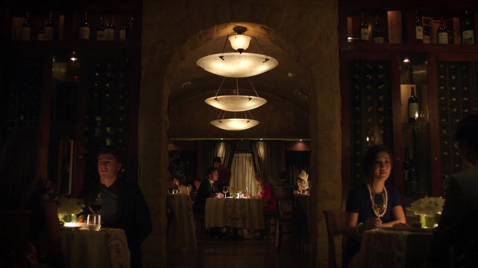 Oliver and Felicity sit together on a date at a fancy restaurant.