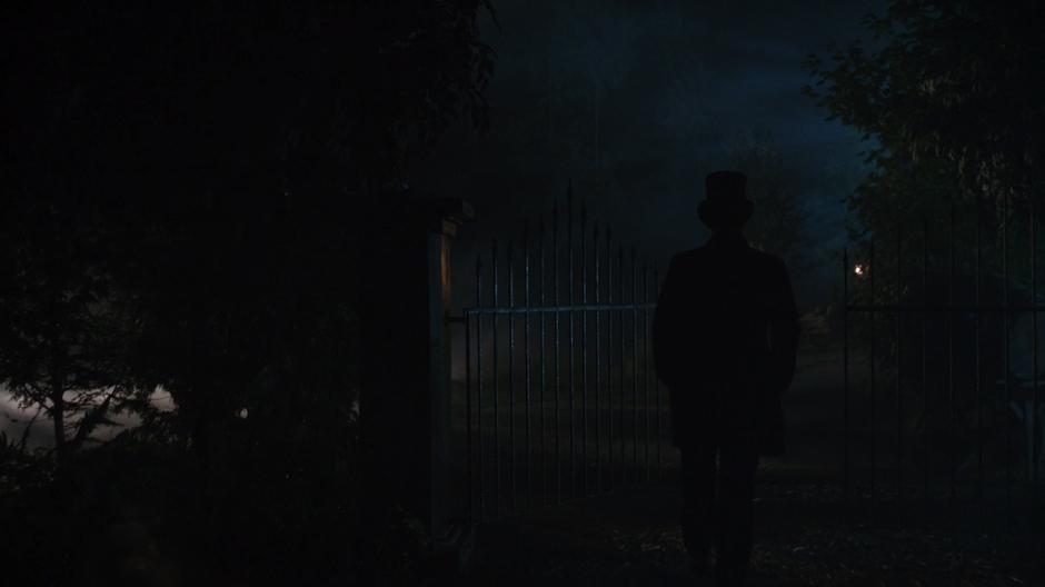 Nate walks out of the town through the gate.