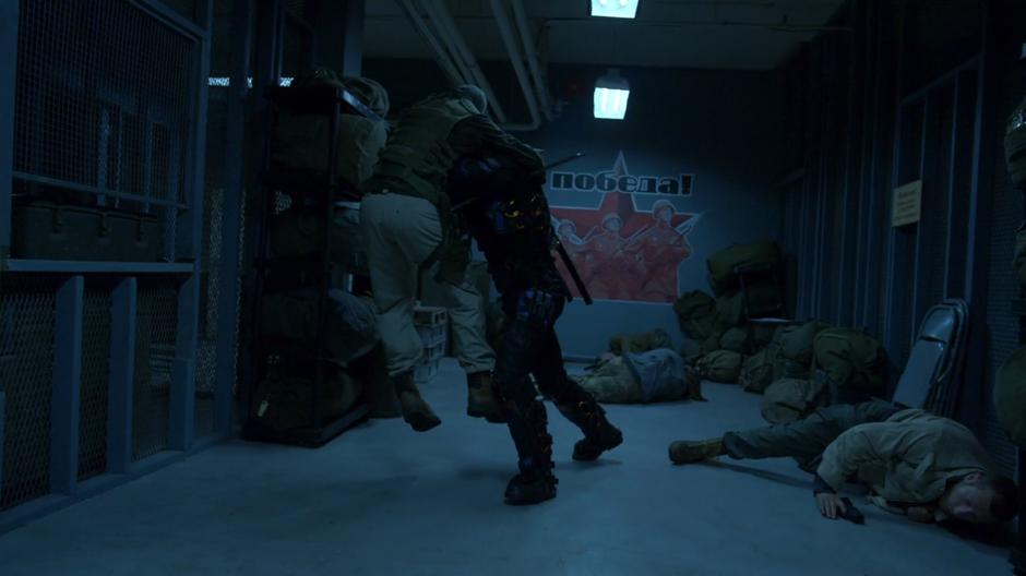 Slade throws one of the Jackals against the wall while two others lie on the ground.