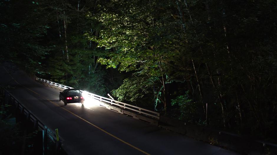 The car slides along the guard rail while trying to hit Alex and Kara.