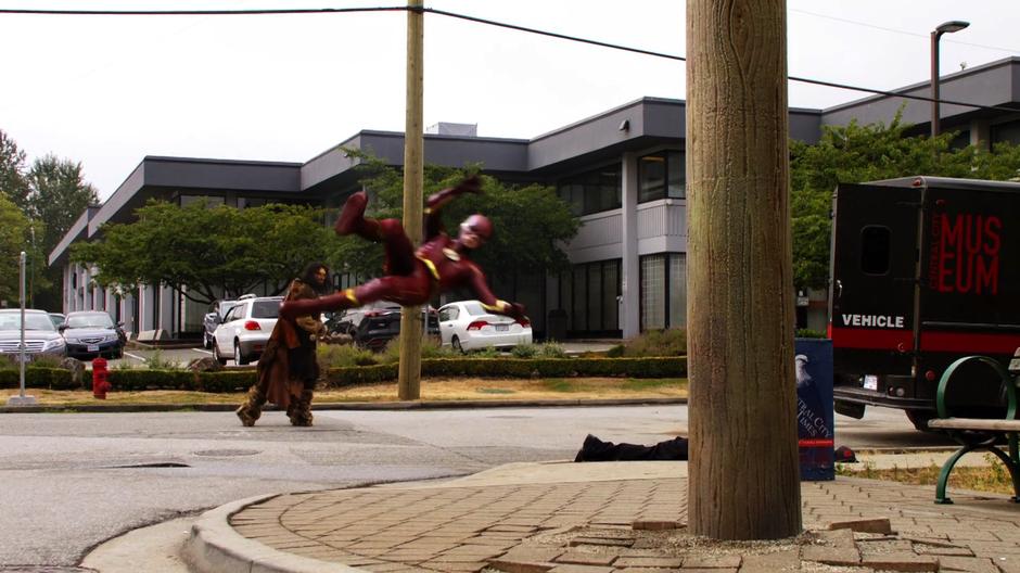 The ancient man statue throws Barry at a telephone pole.