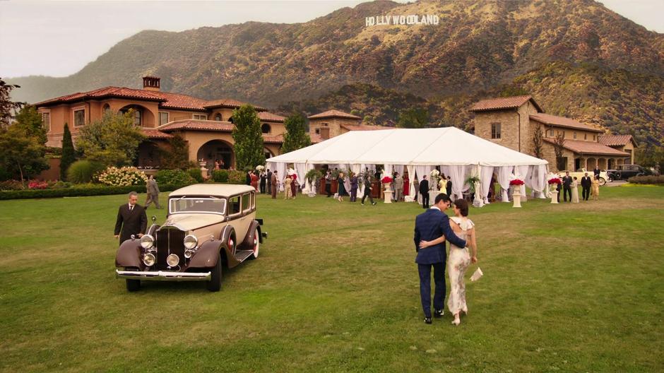 People walk up to the bustling tent set on the lawn of the mansion.