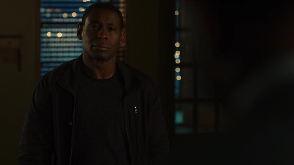 J'onn talks to his father in the new apartment.