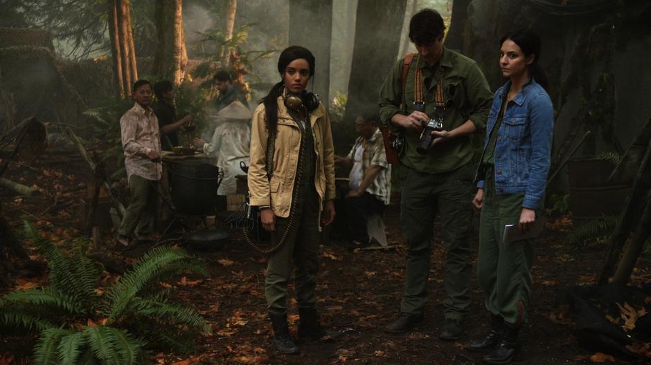 Amaya, Ray, and Zari look around the camp in the jungle.