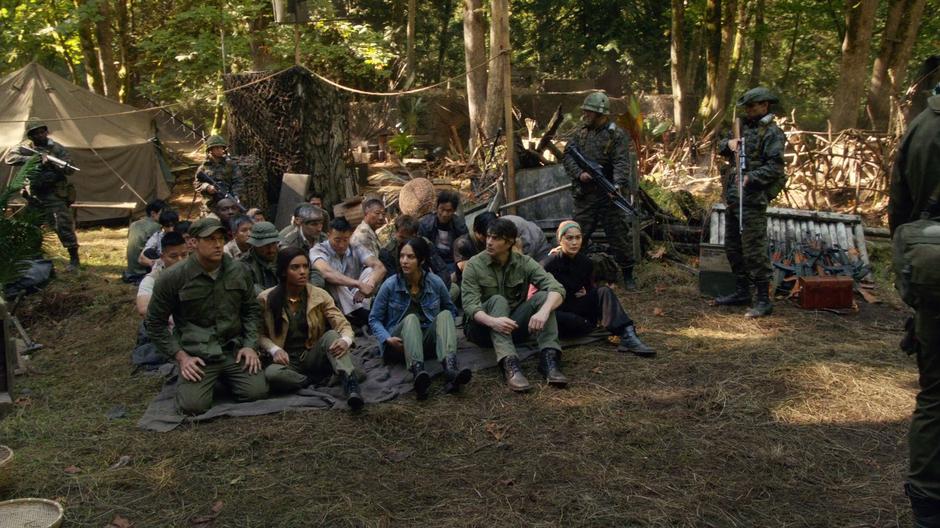 Nate, Amaya, Zari, Ray, and Anh Ly are lined up with the other members of Grodd's camp in front of Dick Rory's soldiers.
