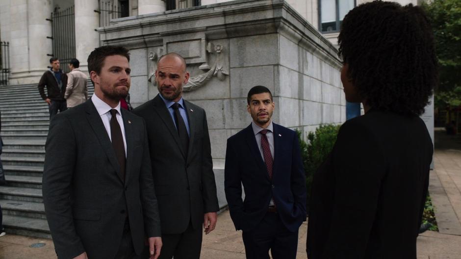 Oliver, Lance, and Rene are approached by Agent Watson after the press conference.