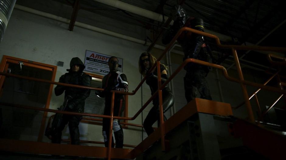 Diggle, Curtis, Dinah, and Rene enter the lab from a catwalk above.