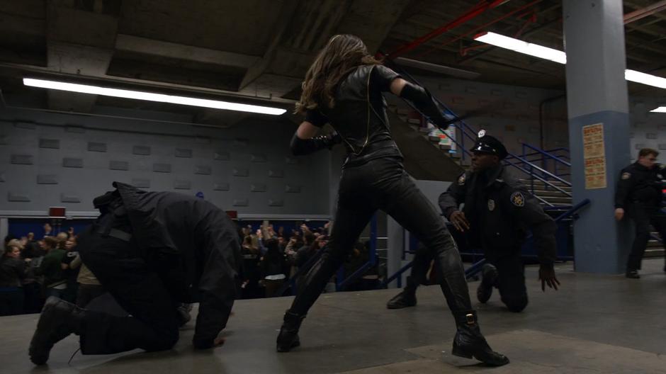 Dinah fights two of the fake police officers in the lobby.
